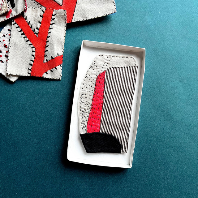 Tableau textile abstrait écru, noir et rouge