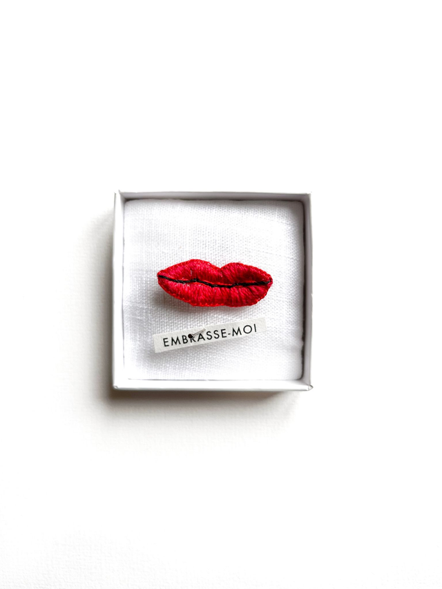 Bouche rouge brodée dans boîte vitrine