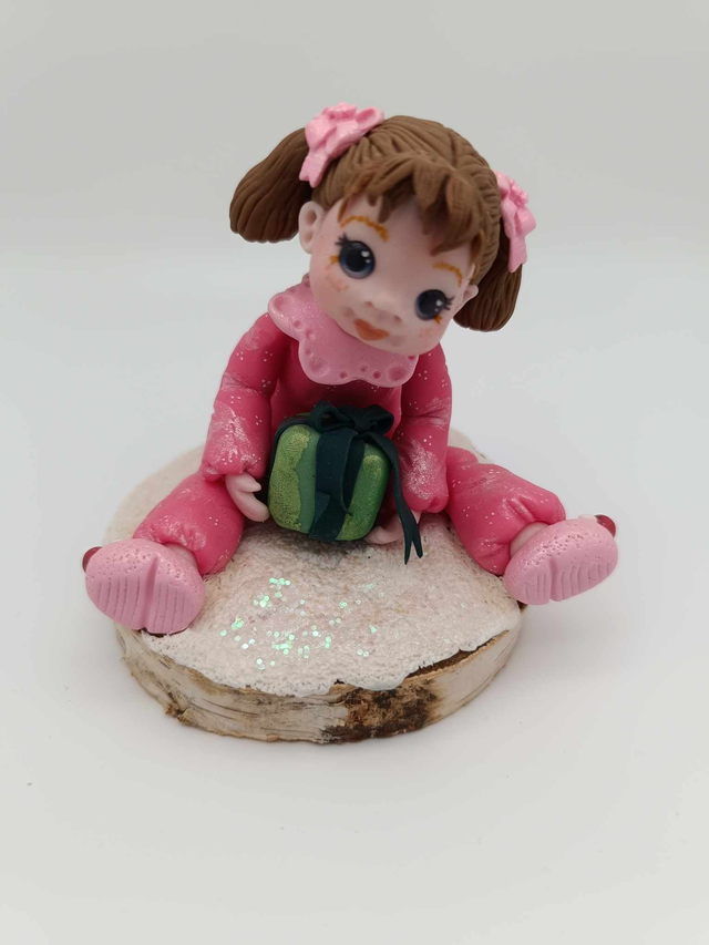 Fillette en porcelaine froide avec un cadeau