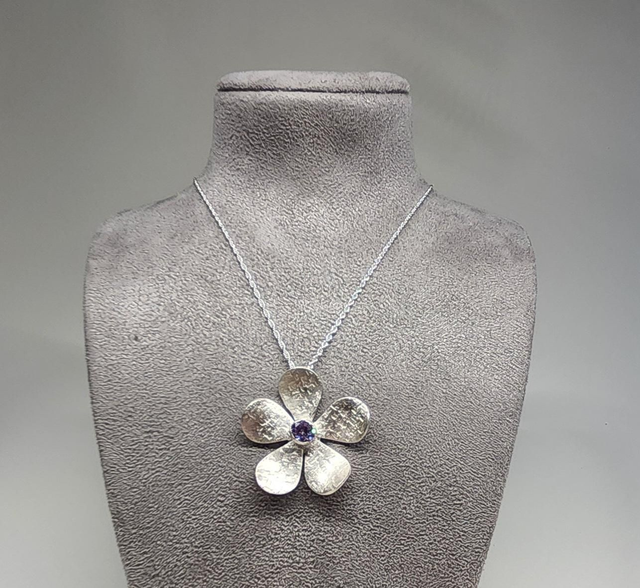 Textured flower pendant with lilac cubic zirconia on silver pendant