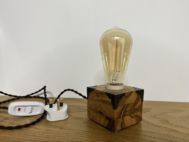 Rustic bedside lamp made of olive wood.
