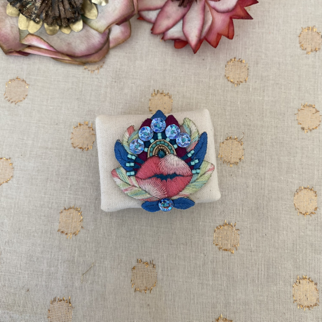Broche bouche et fleur bleue