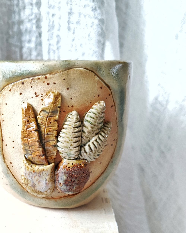 Kubek z nakrapianej gliny z motywem roślin w doniczkach