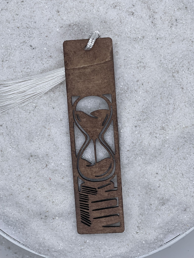 Marque page sablier sur pile de livres.