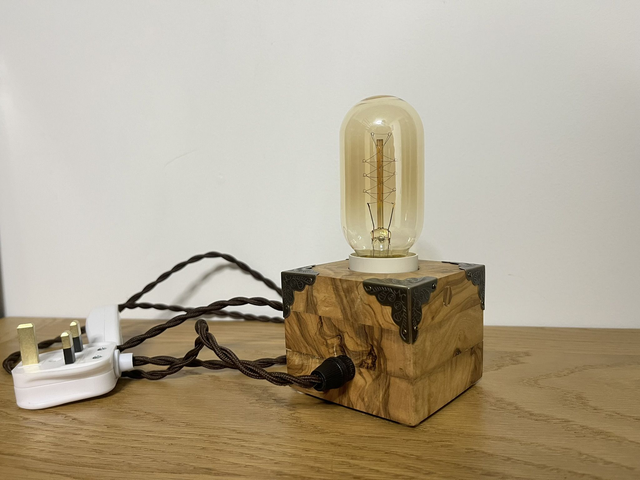 Rustic bedside lamp made of olive wood.