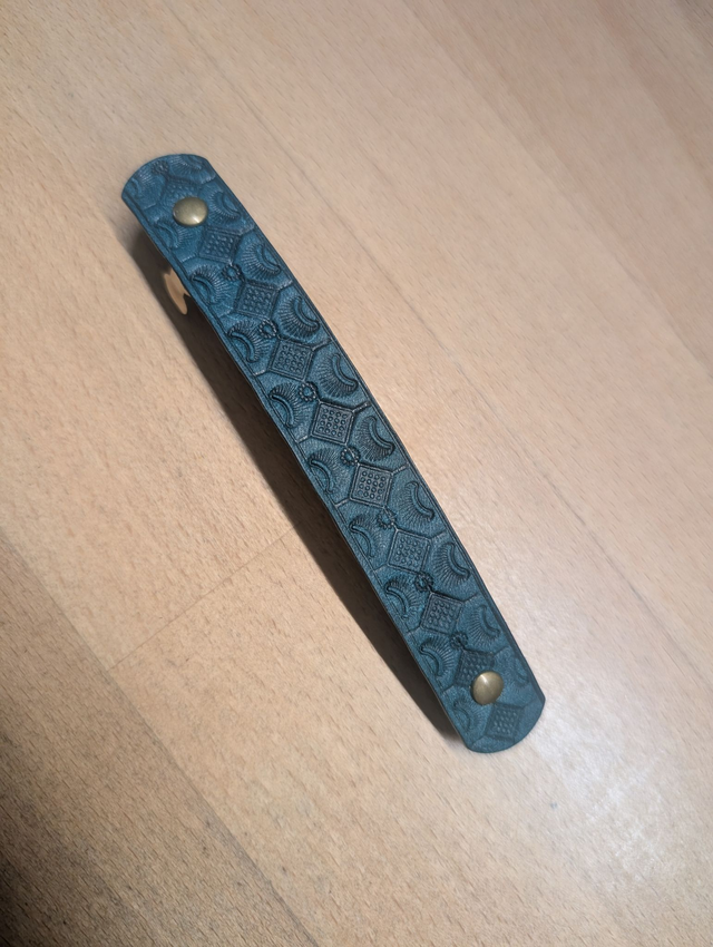 Barrette à cheveux en cuir embossé.