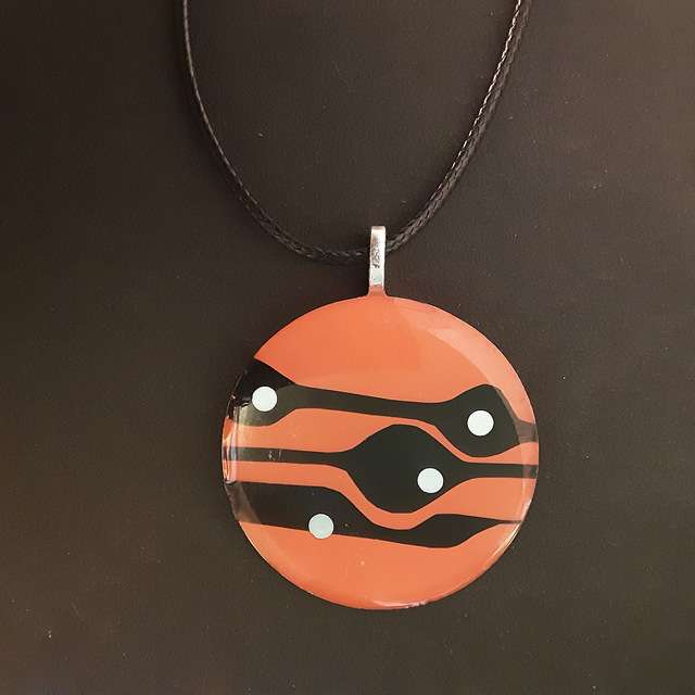 Pendentif rond collection ethnique fond orange flamboyant et impression noire