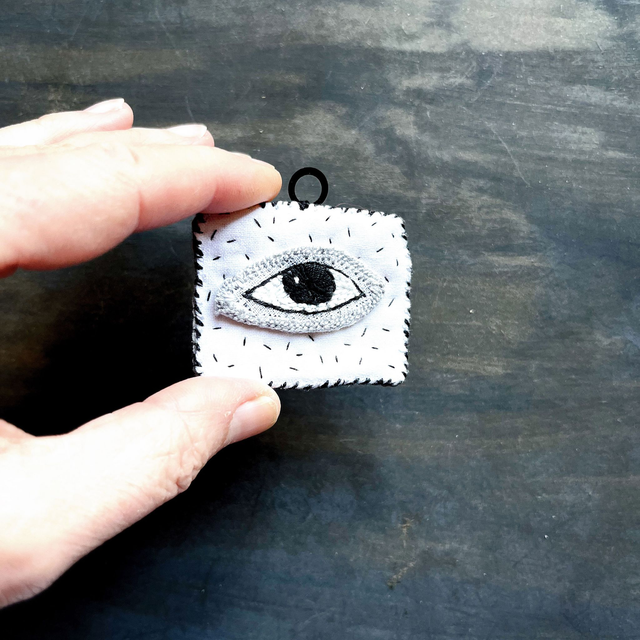 Œil brodé talisman