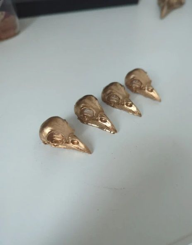 Lot de 4 crânes de corbeau en résine dorée