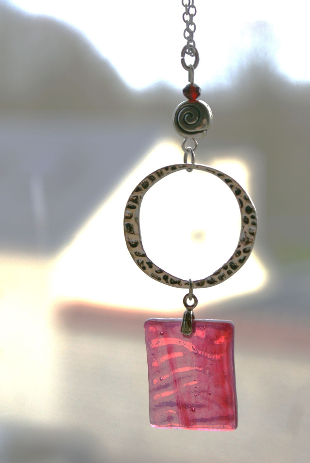 Pendentif en verre rose texturé et chaîne couleur argent. 