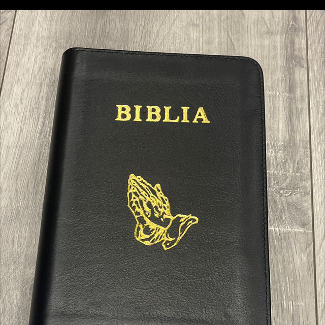 Biblia medie, neagra, maini in rugaciune