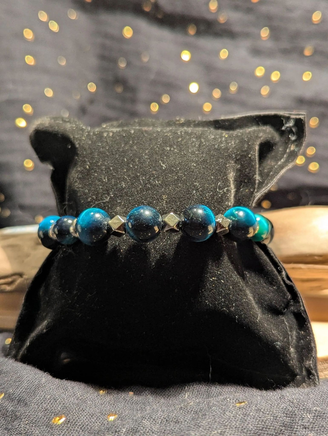 Bracelet en perles d'œil de tigre bleu et des perles d'espacement plate en argent. Le fermoir et la chaine fermoir sont en argent.