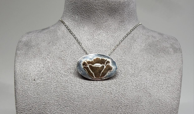 Rose gold poppy pendant on silver necklace