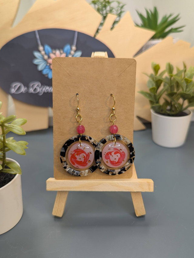 Boucles d&#039;oreilles avec 2 pendentifs ronds, des perles naturelles et un fermoir couleur or. 