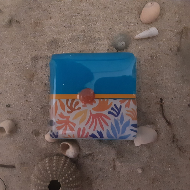 Broche petit carré collection maritime fond bleu turquoise -bande décor floral harmonie de bleu orange et rouge-cabochon rouge translucide