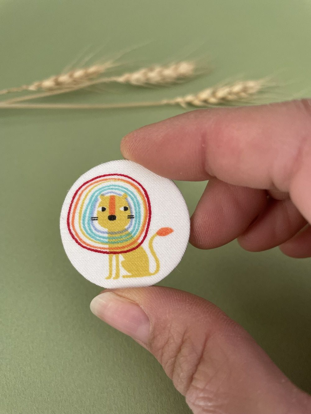 Broche ronde lion crinière arc-en-ciel en carton et tissu imprimé
