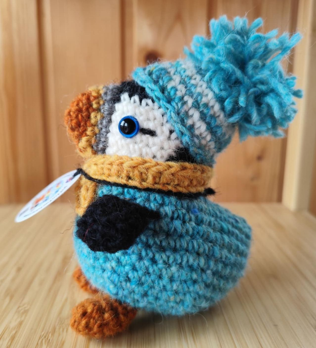 Breezy the puffin wearing glacier blue sweater, scarve and hat (made from Icelandic wool yarn)