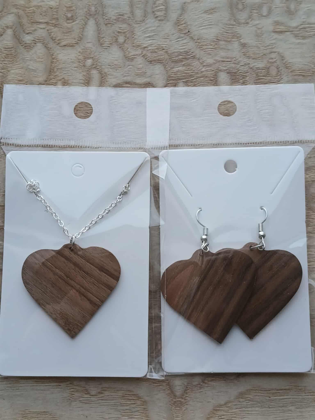 Parure artisanale composée d’une paire de boucles d’oreilles cœur et d’un pendentif assorti, réalisée en bois de noyer.