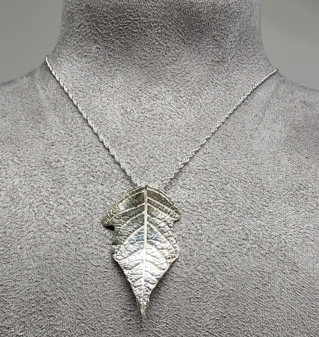Poinsettia leaf pendant on silver necklace