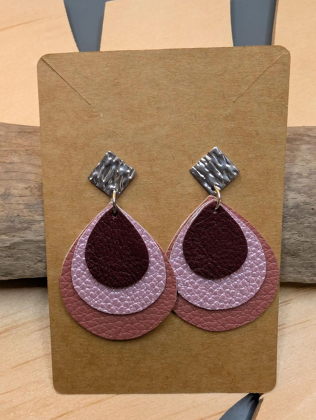 Boucles d'oreilles en cuir en forme de goutte avec un dégradé de rose/violet et le derrière est en blanc. Le fermoir en clou carré est en argent.