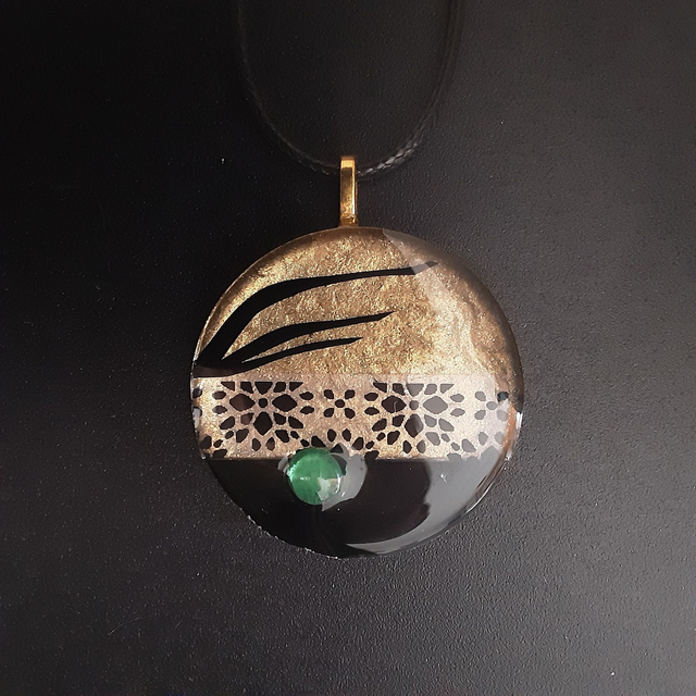 Pendentif rond collection Elégance-fond or et noir-frise noire fleurie-cabochon vert