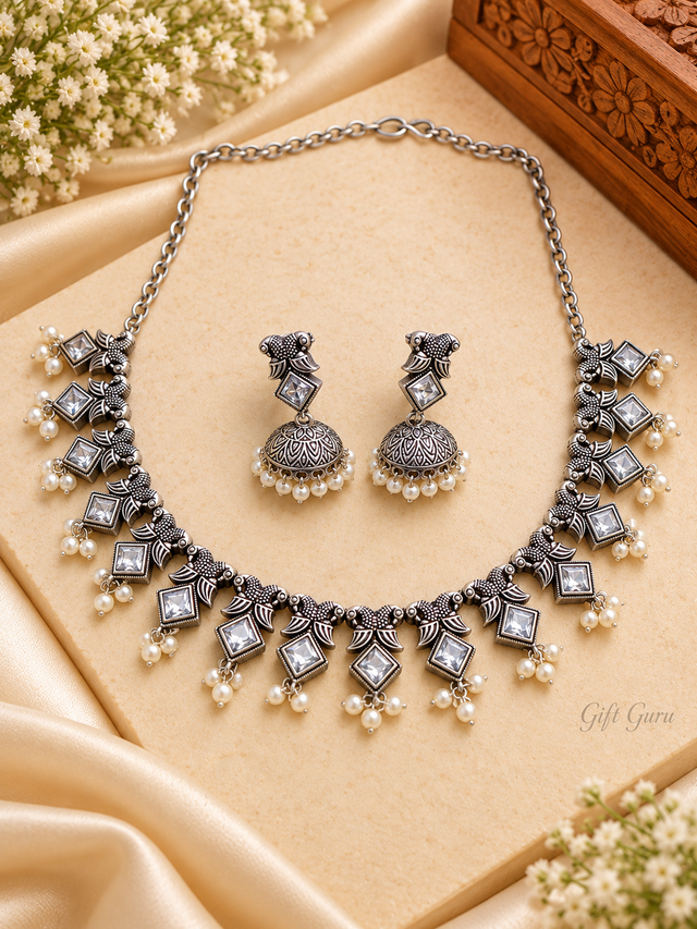 Ethnic oxidised silver-toned choker necklace and matching jhumka earrings set adorned with white stones and small pearl/beaded drops