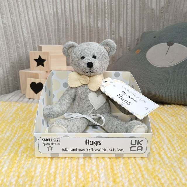 Hugs. Small size, handmade teddy bear. UKCA. Tray base packaging. Limited Edition Wool Felt.  Grey. Pastel yellow. White. Cream. 