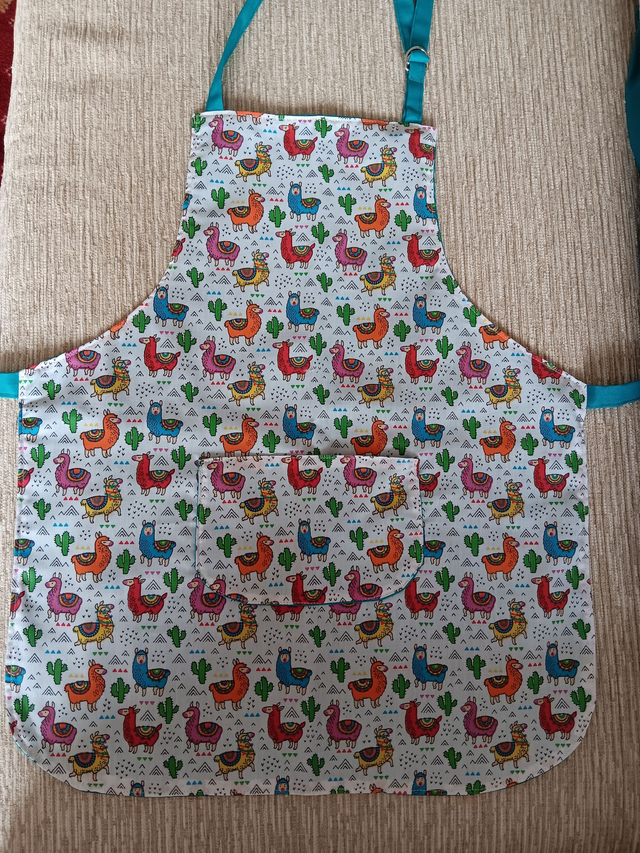 Childs Kitchen Play Apron Llama Patterned Cotton Fabric with Front pocket and turquoise cotton lining, with waist ties and adjustable neck ties