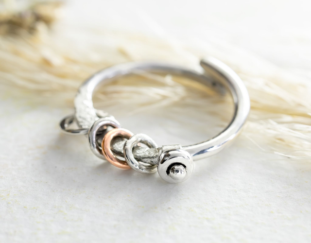 Anillo ajustable con aros hecho a mano en plata 925 y detalle en cobre.