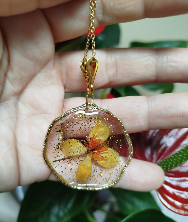 Pendentif rond doré à fleur et éclats dorés 